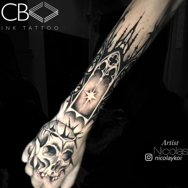 Nicolas Tattoo Artist Realism Black and Grey Skull Missing Teeth Shadows Woven Crown of Thorns Church Above Hand Forearm Tattoo