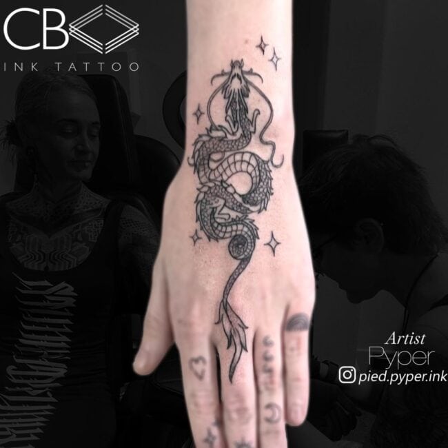 Pyper Tattoo Artist Traditional Black and Grey Chinese Dragon Flying Stars Around Hand Tattoo