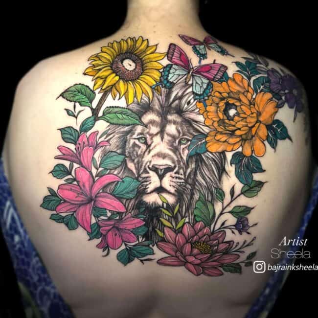 Sheela Tattoo Artist Realism Neo Traditional Colour Lion Surrounded by Multiple Colourful Flower Types Back Tattoo
