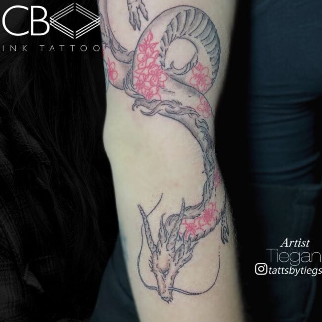 Tiegan Tattoo Artist Traditional Black and Grey and Red Flying Chinese Dragon with Red Patterns Over Body Arm Tattoo