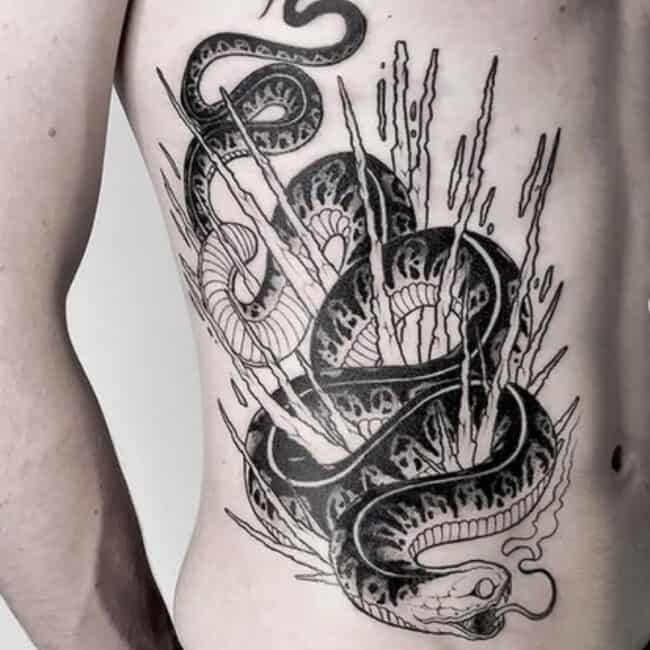Blackwork Tattoo of a Coiled Serpent Symbolising Power and Transformation with Fangs and Forked Teeth Abstract Shards on the Side Waist Tattoo