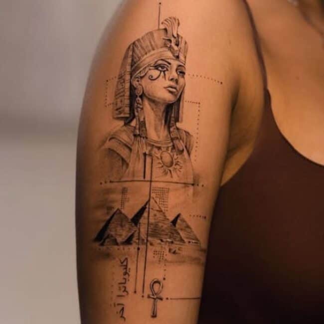 Black and Grey Realism Fine Line Dotwork Cleopatra Portrait Ancient Egyptian Symbol Eye of Horus Pyramid Ankh Shaped Cross with Loop Script Lettering Upper Shoulder Arm Tattoo