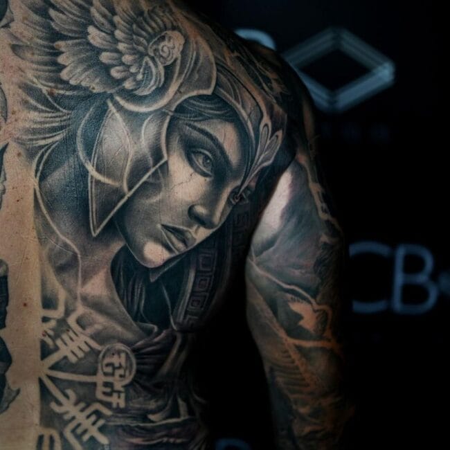Sunny Tattoo Artist Black and Grey Realism Valkyrie Wearing Hinged Helmet Detailed Face Serious Expression Rune Back Shoulder Tattoo