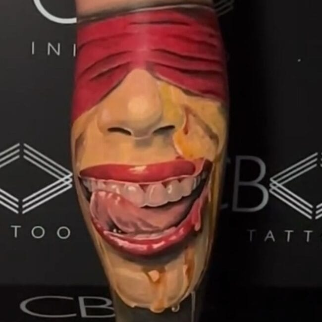 Sunny Tattoo Artist Realism Colour Half Face with Red Blindfold Cloth Wide Smile Exposing Teeth Tongue Sticking Out Calf Leg Tattoo