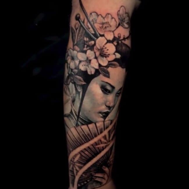 Sunny Tattoo Artist Traditional Realism Geisha Portrait Detailed Eyes Nose Lips with Cherry Blossoms Hairdresser and Folding Fan Forearm Arm Tattoo